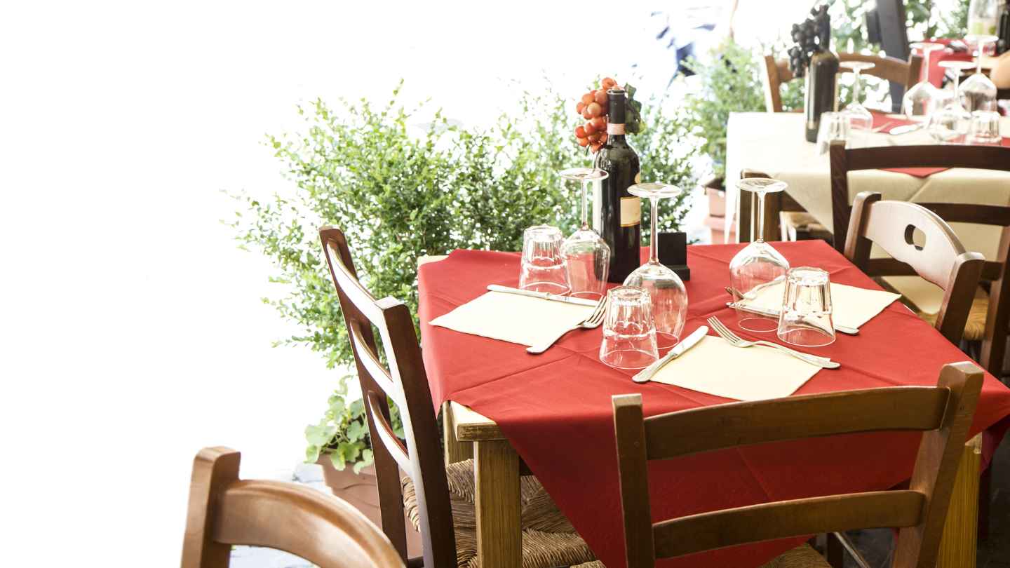 Tavola di una trattoria italiana con piatto tradizionale e menu del giorno